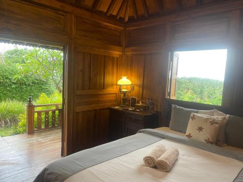 ein Schlafzimmer mit einem Bett mit zwei Handtüchern darauf in der Unterkunft Kepaon Gari Inn in Nusa Penida