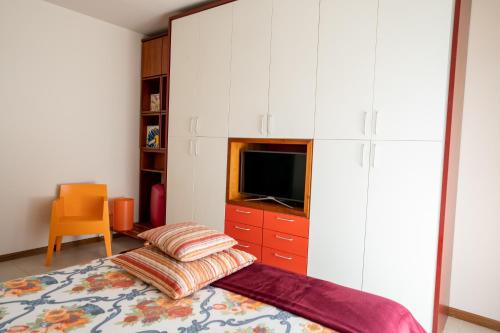 a bedroom with a bed and a tv and cabinets at Casa Terra d'Aci in Aci Bonaccorsi