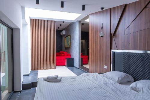 ein Schlafzimmer mit einem Bett und einem roten Sofa in der Unterkunft HOTEL EMROVIC RAJ in Novi Pazar