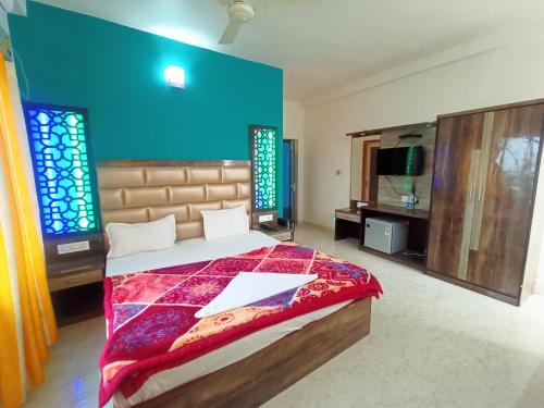 1 dormitorio con cama y pared azul en Blooming Star Guest House en Mandarmoni