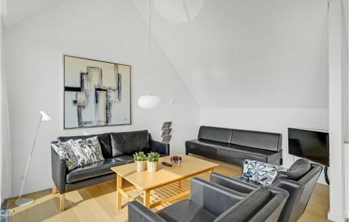 a living room with black leather furniture and a table at 2 Bedroom Cozy Home In Rømø in Sønderby