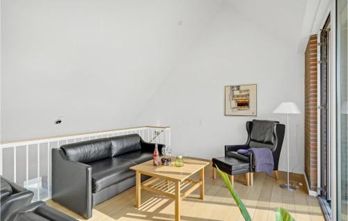 a living room with a leather couch and two chairs at 2 Bedroom Cozy Home In Rømø in Sønderby