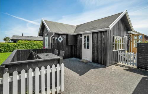 a black house with a white fence in front of it at Awesome Home In Nyborg With Wifi in Nyborg