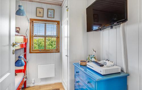 a room with a blue dresser and a television on a wall at Awesome Home In Nyborg With Wifi in Nyborg