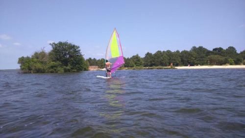 a person on a sail board in the water at mobil home 3chambres tout confort in Gastes