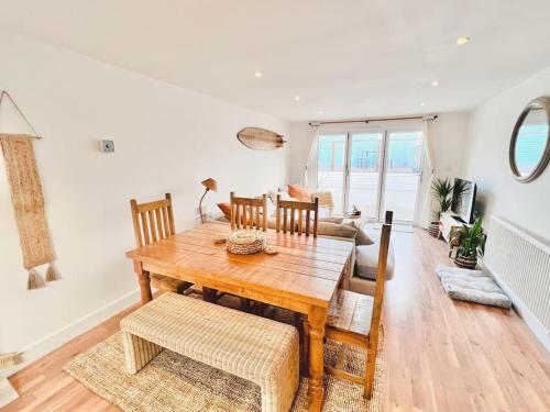a dining room with a wooden table and chairs at The Hideout - Newquay - Fully Stocked Eco Escape in Newquay