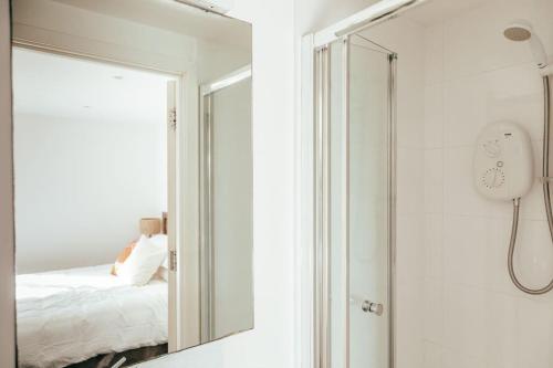 a mirror in a bathroom next to a bed at The Hideout - Newquay - Fully Stocked Eco Escape in Newquay