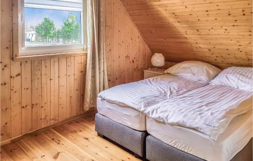 a bed in a wooden room with a window at 2 Bedroom Stunning Home In Sianozety in Sianozety
