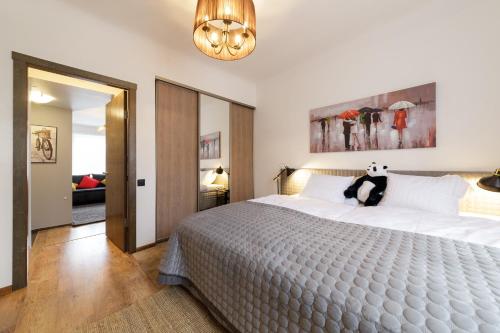 a bedroom with a large bed with a stuffed animal on it at ParkCosyLux Free parking in Rīga