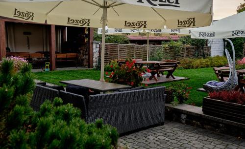 a patio with an umbrella and a table and benches at Bohema Restauracja i Noclegi in Supraśl