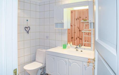 uma casa de banho com um WC, um lavatório e um espelho. em 2 Bedroom Stunning Apartment In Noresund em Noresund