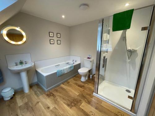 a bathroom with a shower and a sink and a toilet at Lochhournhead B&B & Tea Room in Invergarry
