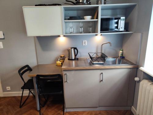 a small kitchen with a sink and a table at Apartamenty Duo in Poznań