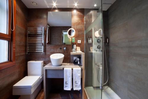 ein Badezimmer mit Waschbecken und Glasdusche in der Unterkunft Petit Palace Tamarises in Getxo