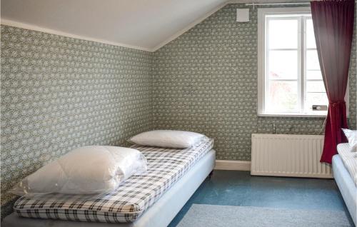 ein kleines Schlafzimmer mit einem Bett und einem Fenster in der Unterkunft 4 Bedroom Lovely Apartment In Orrefors in Orrefors