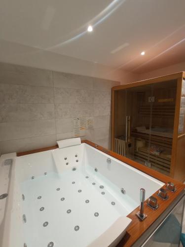 La salle de bains est pourvue d'une grande baignoire blanche. dans l'établissement Gîte Au fil de Drancourt, à Drancourt