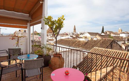 a balcony with tables and chairs and a view of a city at Hotel Madinat in Córdoba