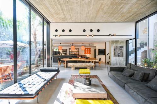 een woonkamer met een bank en een tafel bij The Eucalyptus Mansion by HolyGuest in Tel Aviv
