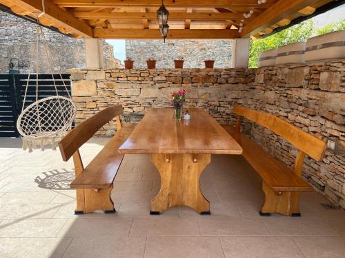 un tavolo in legno e panche su un patio di Apartment Sea a Galižana