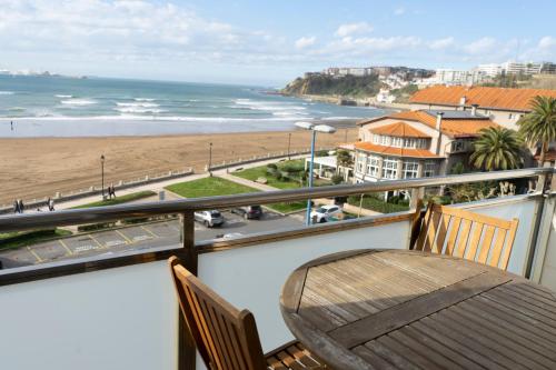 a balcony with a table and a view of the beach at Petit Palace Tamarises in Getxo