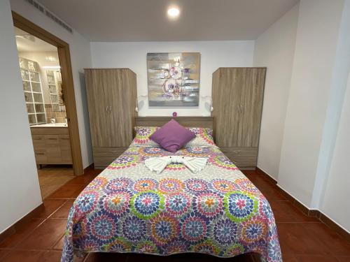 um quarto com uma cama com uma colcha em Apartamento SLAM em Baja Mar