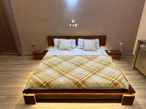 um quarto com uma cama grande e 2 almofadas em Les Résidences de Gorée Porto-Novo em Porto Novo