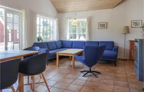 Gorgeous Home In Aakirkeby With Wifi في Vester Sømarken: غرفة معيشة مع أريكة زرقاء وطاولة