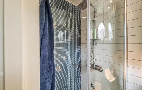 a shower with a blue shower curtain in a bathroom at Stunning Apartment In Marstrand With Kitchen in Marstrand