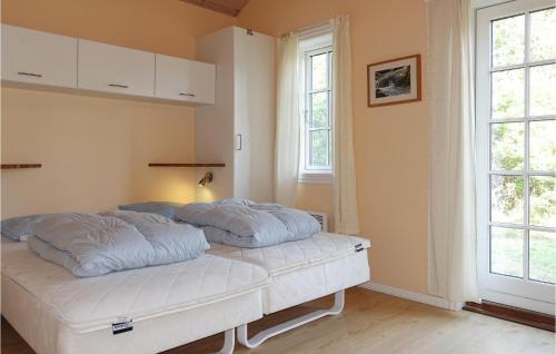 a bed in a room with two pillows on it at Awesome Home In Aakirkeby With 4 Bedrooms And Wifi in Vester Sømarken