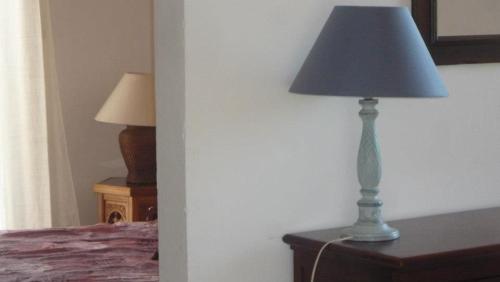 a lamp sitting on a dresser next to a bed at Residence VILLA MOROSI - Favone in Conca