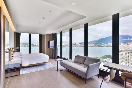 a bedroom with a bed and a view of the water at Four Points by Sheraton Taipei Bali in Bali