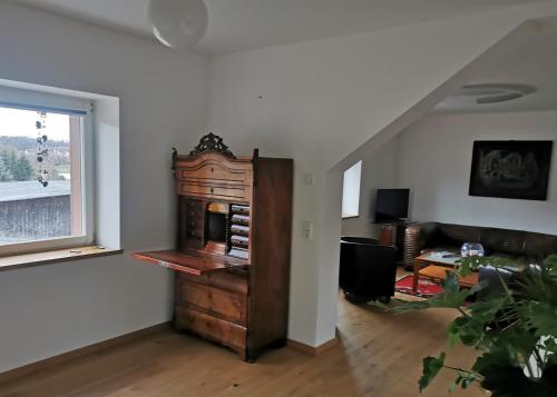 a living room with a wooden cabinet and a window at Große FeWo im Schlossensemble Seußlitz in Bornitz