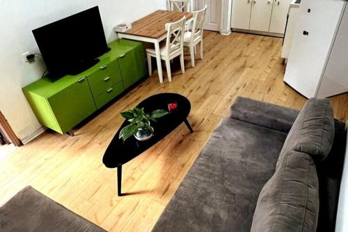 a living room with a couch and a table at יחידת דיור נעימה, יפה ומוארת עם חצר קדמית גדולה in ‘Ilūṭ