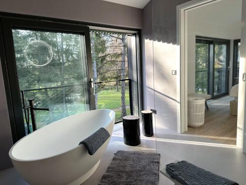 eine Badewanne im Bad mit einem großen Fenster in der Unterkunft Park-Villen in Kressbronn am Bodensee