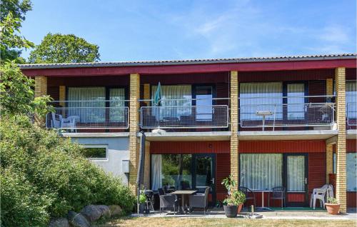 a building with a balcony with tables and chairs at Gorgeous Apartment In Allinge in Allinge