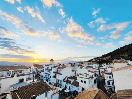 - une vue sur la ville au coucher du soleil dans l'établissement Modern, bright and comfortable apartment with shared roof terrace, à Canillas de Aceituno