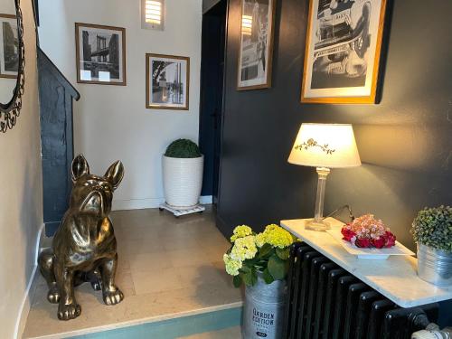 Chez Patou في لافال: ممر فيه تمثال كلب جالس على الارض