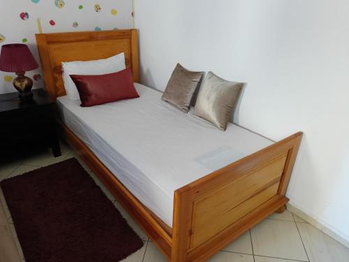 Bett mit vier Kissen auf einem Zimmer in der Unterkunft Appart Majorelle entier au Centre Ville in Kenitra