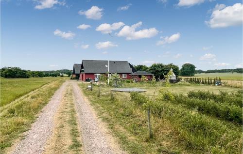 a dirt road in front of a red house at Nice Apartment In Østermarie With Wifi in Østermarie