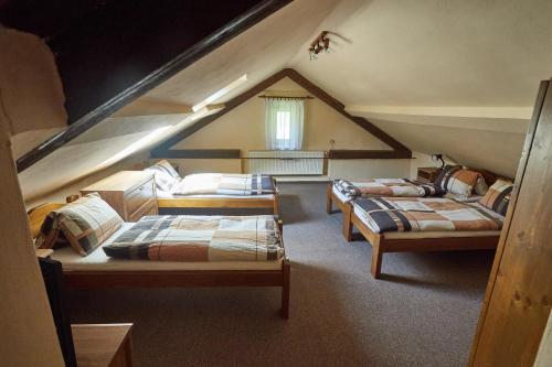 a attic room with three beds in a attic at Chata Slunce in Malá Morávka