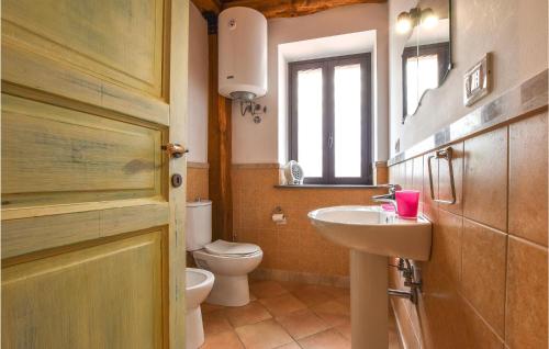 uma casa de banho com um lavatório, um WC e uma janela. em Cozy Home In Santa Venerina With Kitchen em Santa Venerina