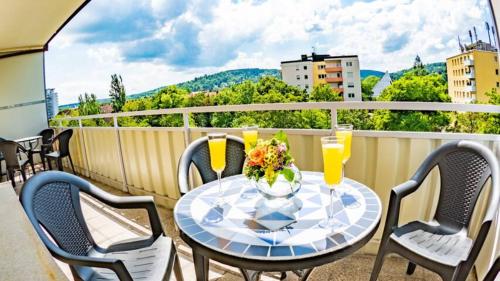 una mesa y sillas en un balcón con vistas en Eleonoras Ferienwohnungen in Würzburg Stadt inklusive eigenen Parkplätzen vor der Tür en Würzburg