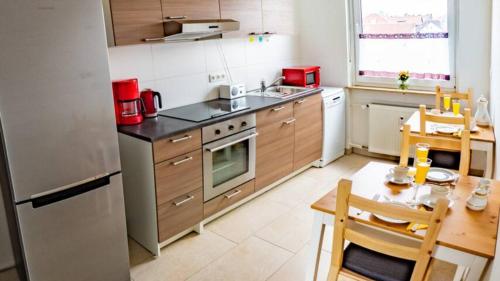 eine kleine Küche mit einem Tisch und einem Kühlschrank in der Unterkunft Eleonoras Ferienwohnungen in Würzburg Stadt inklusive eigenen Parkplätzen vor der Tür in Würzburg