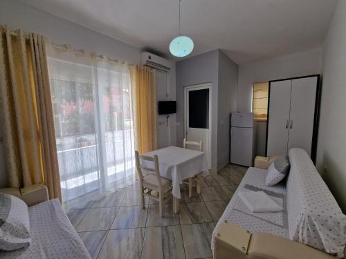 ein kleines Zimmer mit 2 Betten, einem Tisch und einem Fenster in der Unterkunft Hotel Artur2 in Ksamil