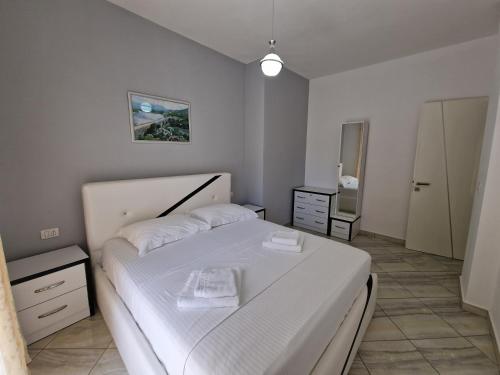a small bedroom with a white bed and a mirror at Hotel Artur2 in Ksamil