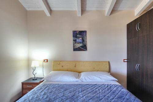 1 dormitorio con 1 cama con cabecero de madera en Sardinia Green Park Country Lodge, en Olbia