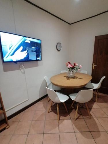 a table with chairs and a television on a wall at Da Adriana al vaticano in Rome