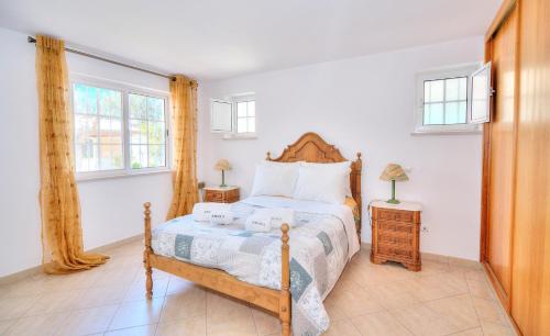 um quarto com uma cama e duas janelas em Amora Classic Villa em Vilamoura