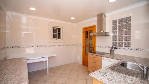 a kitchen with a sink and a counter top at Amora Classic Villa in Vilamoura