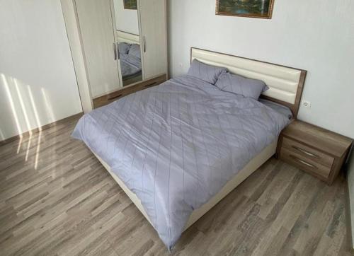 un grande letto in una camera da letto con pavimento in legno di Cozy apartment a Chişinău